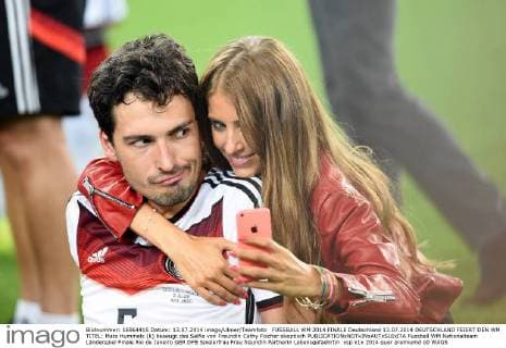 FUSSBALL WM 2014 FINALE Deutschland 13.07.2014 DEUTSCHLAND FEIERT DEN WM TITEL: Mats Hummels (li) beaeugt das Selfie von Freundin Cathy Fischer skeptisch