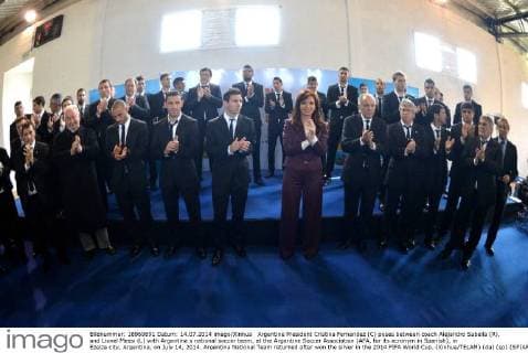 Argentine President Cristina Fernandez (C) poses between coach Alejandro Sabella (R), and Lionel Messi (L) with Argentina s national soccer team, at the Argentine Soccer Association (AFA, for its acronym in Spanish), in Ezeiza city, Argentina, on July 14, 2014. Argentina National Team returned after won the silver in the 2014 FIFA World Cup. (Xinhua TELAM) (da) (sp) (SP)ARGENTINA-EZEIZA-WORLD CUP 2014-NATIONAL TEAM 