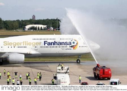 Die Lufthansa-Maschine, umgetauft zur Fanhansa, landet auf dem Flughafen Berlin-Tegel. Die Feuerwehr spritzt zur Begrüßung mit einer Wasserfontäne. Deutsche Nationalmannschaft, Ankunft in Deutschland, WM 2014, 15.07.2014 EP_mht