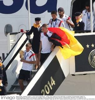 Philipp Lahm (GER) mit dem WM-Pokal und Bastian Schweinsteiger (GER) mit Deutschlandfahne verlassen als Erstes das Flugzeug. Deutsche Nationalmannschaft, Ankunft in Deutschland, WM 2014, 15.07.2014 EP_mht