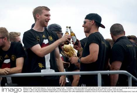 FUSSBALL WM 2014 ANKUNFT DER DEUTSCHEN MANNSCHAFT IN AM 15.07.2014 IN BERLIN Auf dem Fanfest in lässt sich die Deutsche Mannschaft auf der Bühne Feiern: Per Mertesacker (li) und Shkodran Mustafi (re= prosten sich mit dem Sponsor-Bier zu 