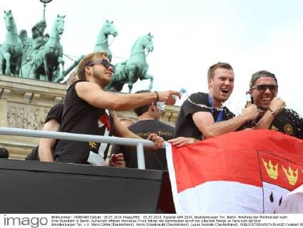 15.07.2014, Fussball WM 2014, Brandenburger Tor, Berlin, Empfang der Weltmeister nach ihrer Rückkehr in Berlin, Auf einem offenen Mercedes-Truck fahren die Weltmeister durch die Jubelnde Menge an Fans zum Berliner Brandenburger Tor. v.li: Mario Götze (Deutschland), Kevin Grosskreutz (Deutschland), Lukas Podolski (Deutschland). 