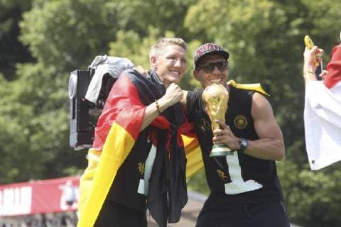 Bastian Schweinsteiger und Lukas Podolski, die deutsche Nationalmannschaft feiert den WM Sieg auf der Fanmeile vor dem Brandenburger Tor am 15.07.2014 in Berlin. Deutsche Nationalmannschaft feiert WM Sieg in Berlin