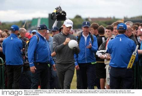 England s Justin Rose signs a golf ball on the final practice day before the 2014 Open Golf Championships in Hoylake on July 16, 2014.  LON2014071613