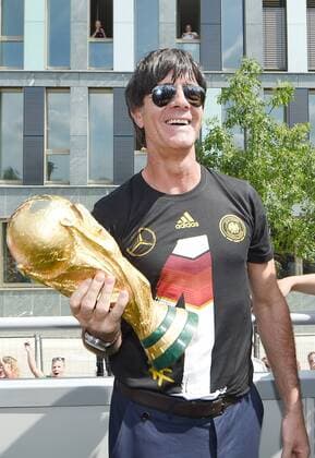 Auf dem Truck: Bundestrainer Trainer Joachim Jogi LÖW (Deutschland) schaut auf den WM Pokal und lacht. Empfang WM-Party Fahrt auf einem LKW Truck zur Feier der deutschen Fussball Nationalmannschaft auf die Fanmeile am Brandenburger Tor in Berlin- FIFA - Fussball Weltmeisterschaft 2014, Fanmeile Berlin, Deutschland, 15.07.2014- WC party of the german national team men- FIFA- Soccer World Cup 2014