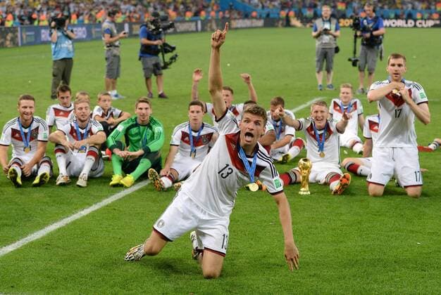 FUSSBALL WM 2014 FINALE Deutschland - Argentinien 13.07.2014 DEUTSCHLAND FEIERT DEN WM TITEL 2014: Thomas Mueller (vorn mitte) macht Stimmung und Shkodran Mustafi, Miroslav Klose, Christoph Kramer, Torwart Ron-Robert Zieler, Julian Draxler, Mario GÖTZE, Bastian Schweinsteiger, Andre Schürrle und Per Mertesacker (hinten v.li.) feiern mit dem WM Pokal