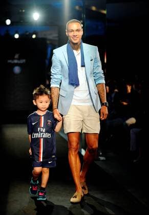 Gregory van der Wiel of France s Paris Saint-Germain Football Club, right, walks with a little boy at a fashion show of Swiss watch brand Hublot during the Asia tour of the club in Hong Kong, China, 27 July 2014. Paris Saint-Germain football stars wow fans at watch fashion show in Hong Kong  20140727_10767