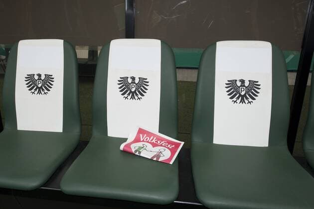 Fußball, Stadiongeschichte Preußen Münster Preussen Muenster --- Fussball --- DFB-Pokal --- 17.08.2014 Muenster, Ersatzbank mit Vereinswappen, darauf eine Zeitung mit der Aufschrift Volksfest, Logo, Feature, Symbolfoto, Symbolbild