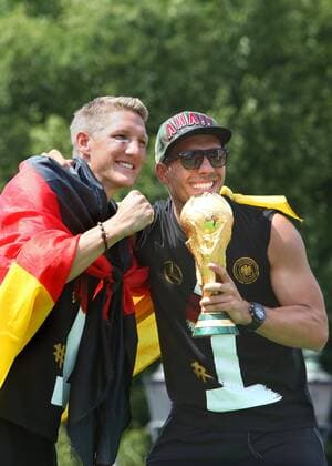 Berlin-Mitte: Fanfest auf der Straße des 17. Juni vor dem Brandenburger Tor anlässlich der FIFA Fußball WM 2014 in Brasilien. - Empfang der Weltmeister - Sebastian Schweinsteiger und Lukas Podolski beim Feiern mit WM-Pokal