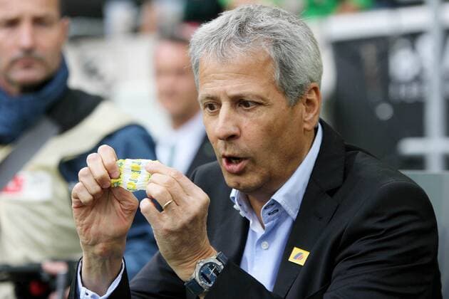 Borussia Mönchengladbach vs. VfB Stuttgart --- Fussball --- 1.Bundesliga --- 24.08.2014 Lucien Favre (Trainer Mönchengladbach), schaut auf eine Bonbonverpackung von Ricola, Schweizer Kräuterbonbons, Kräuterbonbons, witzig, lustig, Einzelbild, halbe Figur