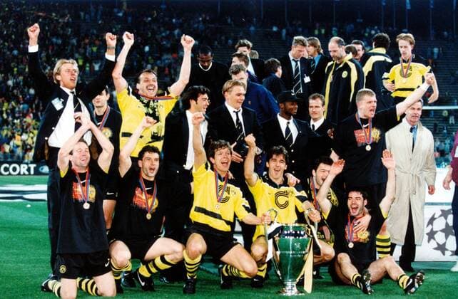 Borussia Dortmund ist Champions League-Sieger, hi.v.li.: Frank Riethmann, Jürgen Kohler, Jovan Kirovski, Vladimir But, Ibrahim Tanko, Rene Schneider, Martin Kree, Trainer Ottmar Hitzfeld, sowie dahinter Jörg Heinrich; vo.v.li.: Paul Lambert, Michael Zorc, Andreas Möller, Karl Heinz Riedle, Stephane Chapuisat und Rene Tretschok