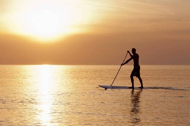 Germany, Schleswig Holstein, Man on stand up paddle board on Baltic sea model released  DBF000223