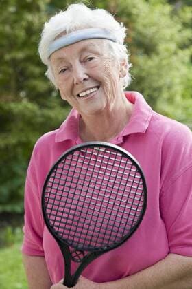 Germany, Bavaria, Huglfing, Senior woman holding badminton racket, smiling, portrait model released  RIMF000012