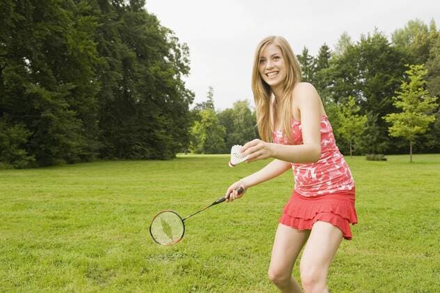 Germany, Bavaria, Starnberger See, Young woman playing badminton, smiling, portrait model released  RNF00064