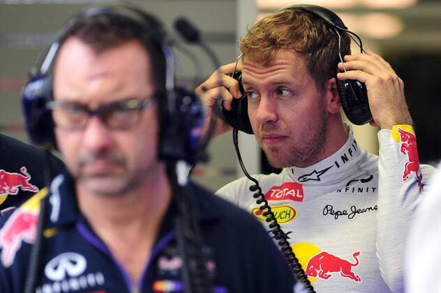 Redbull driver Sebastian Vettel (R) awaits in his team garage during the second practice session at the Singapore F1 Night Race on Sept. 19, 2014. Singapore F1 Night Race held 2 practice sessions at the Marina Bay Street Circuit in Singapore. ) (SP)SINGAPORE-F1-PRACTICE ThenxChihxWey 