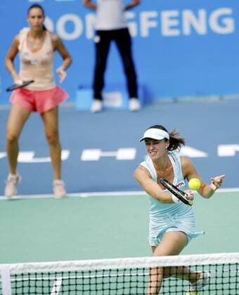 Martina Hingis of Switzerland, front, returns a shot as she and Flavia Pennetta of Italy compete during the women s doubles semifinals of the 2014 WTA Tennis Damen Wuhan Open tennis tournament in Wuhan city, central China s Hubei province, 26 September 2014.  20140926_44369