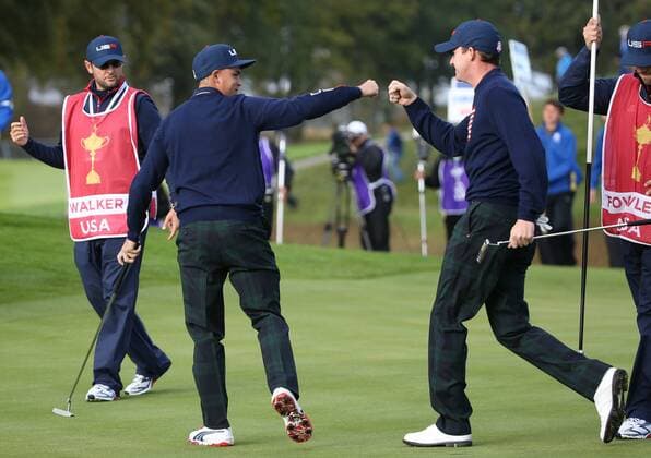 USA s Rickie Fowler (L) fist pumps Jerry Walker in the morning fourball match against Europe s Rory McIlroy ( Mc Ilroy ) and Ian Poulter on the second day of the 2014 Ryder Cup in Gleneagles,Scotland on September 27, 2014.The match was halved.  LON2014092715