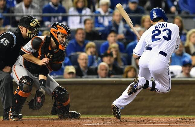 Kansas City Royals right fielder Nori Aoki (23) leaps to avoid a pitch against the San Francisco Giants with catcher Buster Posey coming up with the pitch during the first inning of game 7 of the World Series at Kaufman Stadium in Kansas City, Missouri on October 29, 2014. Tied at 3 games apiece, the winner, San Francisco or Kansas City, will be champion.  KCP2014102909