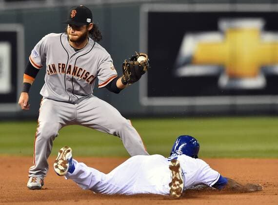 San Francisco Giants shortstop Brandon Crawford (L) tags out Kansas City Royals center fielder Lorenzo Cain on a stolen base attempt during the first inning of game 7 of the World Series at Kaufman Stadium in Kansas City, Missouri on October 29, 2014. Tied at 3 games apiece, the winner, San Francisco or Kansas City, will be champion.  KCP2014102919