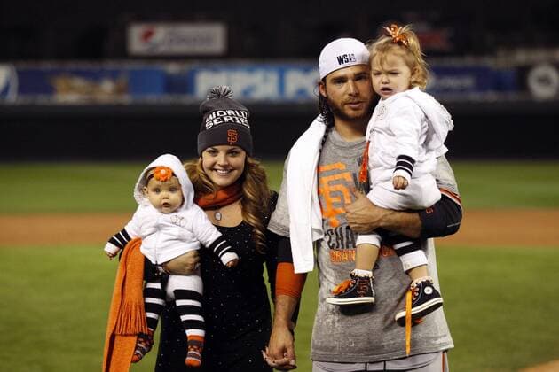 San Francisco Giants shortstop Brandon Crawford stands with his wife Jalynne Dantzscher and their two daughters Jaydyn April Crawford and Braylyn Ann Crawford after game 7 of the World Series against the Kansas City Royals at Kauffman Stadium in Kansas City, Missouri on October 29, 2014. The Giants defeated the Royals 3-2 to win the World Series.  KCP20141029222