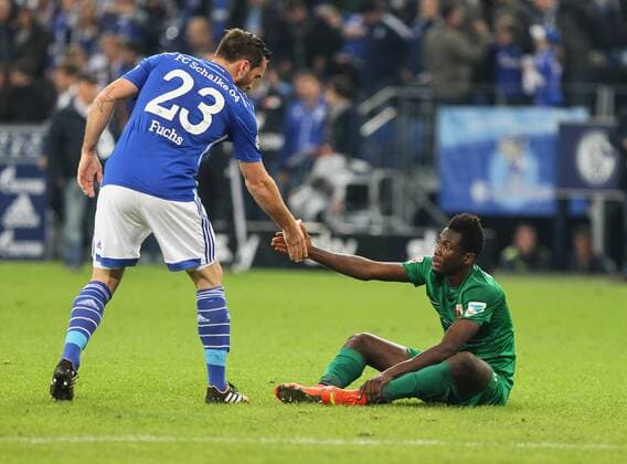 Abdul Rahman Baba (FC Augsburg 12) sitzt nach dem Schlusspfiff enttaeuscht auf dem Rasen, Christian Fuchs (Schalke 04) hilft ihm auf, FC Schalke 04 vs. FC Augsburg, Fussball, Bundesliga, 10. Spieltag, Saison 2014-2015, 31.10.2014,