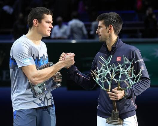 Milos Raonic of Canada (L) and Novak Djokovic of Serbia hold their trophies after Djokovic won their BNP Paribas Masters finals match in Paris on November 2, 2014.  PAR20141102732