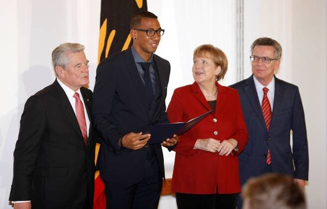 10.11.2014, Berlin, Verleihung des Silbernen Lorbeerblattes an die Spieler der Fußball-Nationalmannschaft durch den Bundespräsidenten Joachim Gauck im Schloss Bellevue. Bild: Bundespräsidenten Joachim Gauck, Bundeskanzlerin Angela Merkel und Thomas de Maiziere übereichen Jerome Boateng das Silberne Lorbeerblatt Verleihung des Silbernen Lorbeerblattes an die Spieler der Fußball-Nationalmannschaft