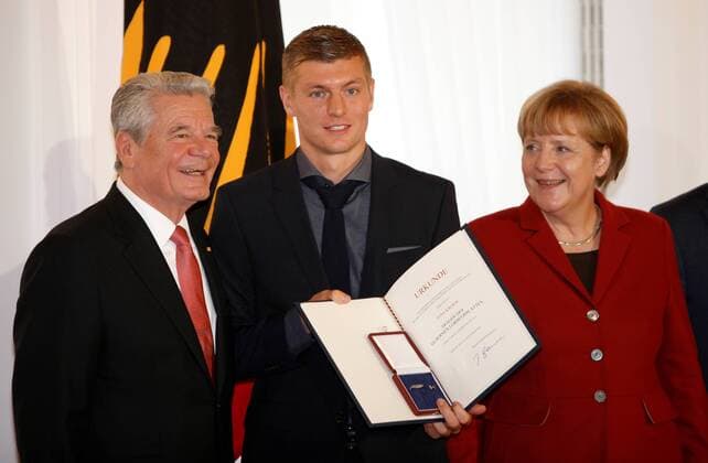10.11.2014, Berlin, Verleihung des Silbernen Lorbeerblattes an die Spieler der Fußball-Nationalmannschaft durch den Bundespräsidenten Joachim Gauck im Schloss Bellevue. Bild: Bundespräsidenten Joachim Gauck, Bundeskanzlerin Angela Merkel übereichen Toni Kroos das Silberne Lorbeerblatt Verleihung des Silbernen Lorbeerblattes an die Spieler der Fußball-Nationalmannschaft