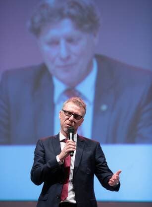 Fußball Bundesliga - Jahreshauptversammlung des 1. FC Köln in der Lanxess-Arena in Köln. FC-Trainer Peter Stöger spricht auf der Bühne, im Hintergrund ist Toni Schumacher auf der Leinwand zu sehen. 1. FC Köln