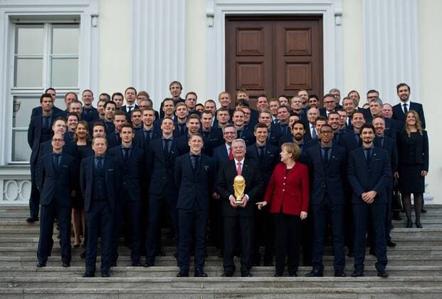 Miroslav KLOSE, Torwart Manuel NEUER, Bastian SCHWEINSTEIGER, Bundespräsident Joachim GAUCK mit dem Weltmeisterpokal, Bundeskanzlerin Angela MERKEL, Jerome BOATENG, Mats HUMMELS (vordere Reihe, vl), sowie die Nationalmannschaft posieren für ein Gruppenfoto vor dem Schloss Bellevue. Sportlerauszeichnung - Verleihung des Silbernen Lorbeerblattes durch den Bundespräsidenten für die deutsche Fussballnationalmannschaft im Schloss Bellevue in Berlin, Deutschland am 10.11.2014.
