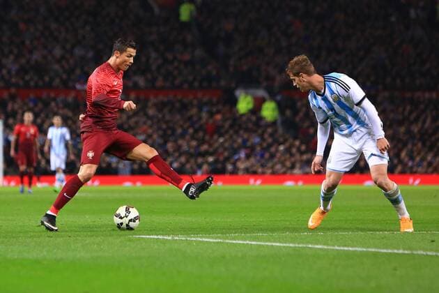 Cristiano Ronaldo of Portugal demonstrates his footwork against Cristian Ansaldi of Argentina - Argentina vs. Portugal - International Friendly - Old Trafford - Manchester - 18 11 2014 Pic PhilipOldham Sportimage EDITORIAL USE ONLY. No use with unauthorised audio, video, data, fixture lists, club league logos or live services. Online in-match use limited to 120 images, no video emulation. No use in betting, games or single club league player publications.
