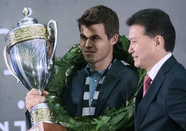 SOCHI, RUSSIA.NOVEMBER 25, 2014. Kirsan Ilyumzhinov, the president of the World Chess Federation (FIDE), right, looks on as chess champion Magnus Carlsen of Norway holds up his trophy at an awarding ceremony after winning the FIDE World Chess Championship 2014.  premiumd RE155CEA