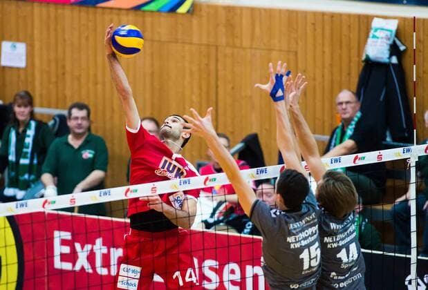 Bestensee, Deutschland, 26.11.2014: Volleyball Bundesliga Saison 2014 2015 - Netzhoppers KW - TV Buehl Bühl. Mark Plotyczer (Buehl) gegen den Block aus Georg Escher (Netzhoppers 15), Paul Sprung (Netzhoppers 14)