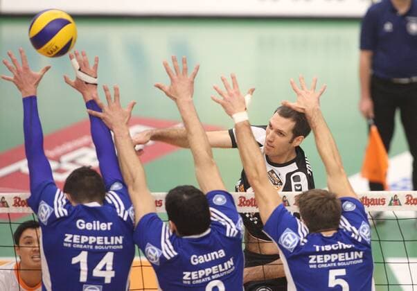 Friedrichshafen, Deutschland, 11.12.2014: Volleyball Bundesliga Saison 2014 2015 - VfB Friedrichshafen - BR Volleys. Scott Joseph Touzinsky (BR Volleys 1) gegen den Block aus v.li. Baptiste Geiler (Friedrichshafen 14), Maximiliano Gauna (Friedrichshafen 2), Simon Tischer (Friedrichshafen 5)