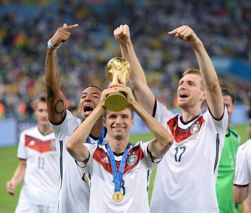 FUSSBALL WM 2014 FINALE Deutschland - Argentinien 13.07.2014 DEUTSCHLAND FEIERT DEN WM TITEL 2014: Thomas Mueller (Mitte) mit Per Mertesacker (re) und Jerome Boateng (li) jubelt mit dem WM Pokal 
