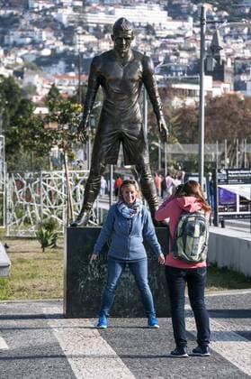 Fussball, Touristin lässt sich vor der Statue von Cristiano Ronaldo, CR7 (Real Madrid) im Hafen seiner Heimat Funchal, Madeira, fotografieren.