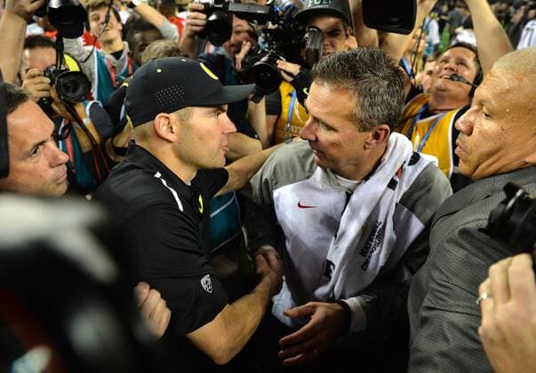 Ohio State Buckeyes head coach Urban Meyer (R) shakes hands with Oregon Ducks head coach Mark Helfrich after the Buckeyes defeated the Oregon Ducks 42-20 to win the College Football Playoff National Championship, in Arlington, Texas on January 12, 2015.  ARL20150112413 KEVINxDIETSCH