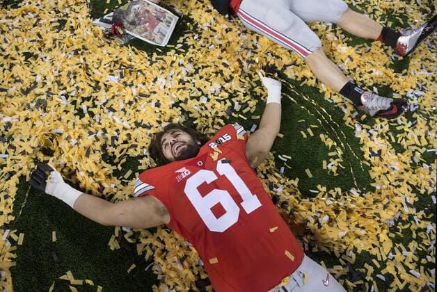 Ohio State Buckeyes offensive lineman Logan Gaskey (61) makes a snow angle in confetti as he celebrates after the Buckeyes defeated the Oregon Ducks to win the College Football Playoff National Championship, in Arlington, Texas on January 12, 2015. The Buckeyes defeated the Ducks 42-20.  ARL20150112420 KEVINxDIETSCH