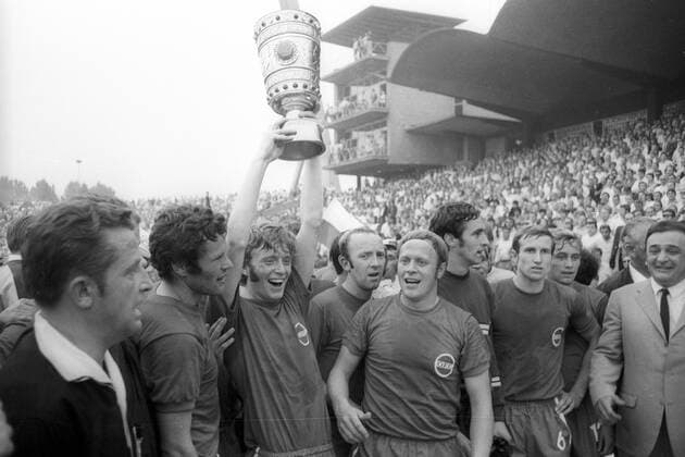 Die Kickers Offenbach gewinnen den DFB-Pokal, v.li.: Schiedsrichter Gerhard Schulenburg, Hans Reich, Winfried Schäfer mit dem Pokal, Horst Gecks, Josef Weilbächer, Torwart Karlheinz Volz, Egon Schmitt, Helmut Nerlinger und Präsident Horst Gregorio Canellas