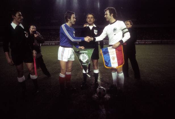 Frankreich - BR Deutschland in Paris: Die Kapitäne Bernard Lacombe (li., Frankreich) und Franz Beckenbauer (BRD) begrüßen sich, mi.: Schiedsrichter Sanchez Ibanez