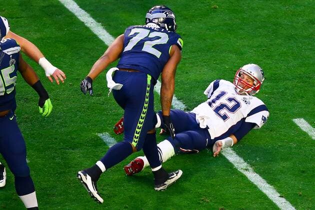 01 FEB 2015: New England Patriots quarterback Tom Brady (12) gets knocked down by Seattle Seahawks defensive end Michael Bennett (72) during the first quarter of Super Bowl XLIX being played at University of Phoenix Stadium. The New England Patriots defeat the Seattle Seahawks 28-24 in Super Bowl XLIX at University of Phoenix Stadium in Glendale Arizona. NFL American Football Herren USA FEB 01 Super Bowl XLIX - Patriots v Seahawks Icon020115328 EDITORIAL USE ONLY