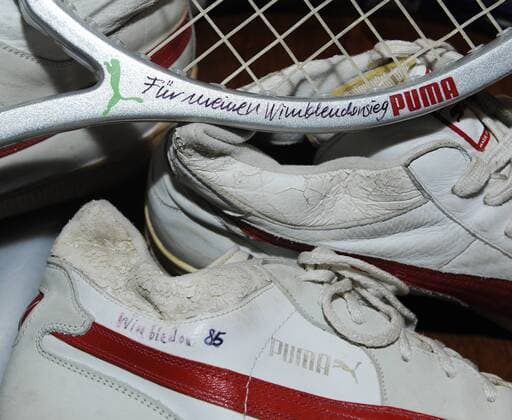 Sportartikel von Puma mit Widmungen berühmter Sportler: Tennisschuhe von Boris Becker mit dem Schriftzug 1985 Wimbledon sowie Tennisschläger mit dem Schriftzug für meinen Wimbledon-Sieg