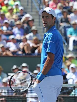 Novak Djokovic of Serbia waits at the net after winning his men s semifinal match at the BNP Paribas Open in Indian Wells, California on March 21, 2015.  IDW20150321718 DAVIDxSILPA