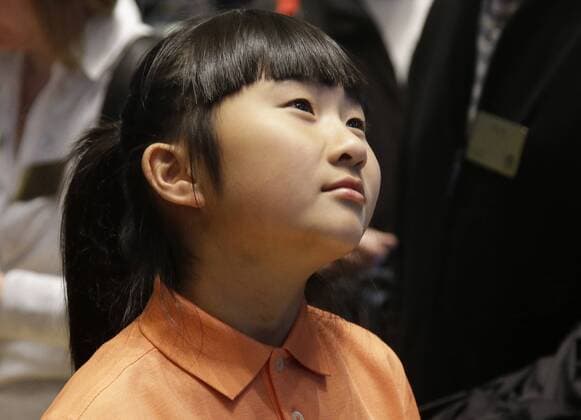 Ten-Year-Old Drive, Chip & Putt Champion Kelly Xu stands on the floor of the NYSE before the closing bell at the New York Stock Exchange on Wall Street in New York City on March 24, 2015. Their appearance at the NYSE is to celebrate Bubba Watson s defense of his 2014 Masters title just two weeks later and KellyÕs defense of her Drive, Chip and Putt title at Augusta National the Sunday before the Masters Tournament.  NYP20150324105 JOHNxANGELILLO