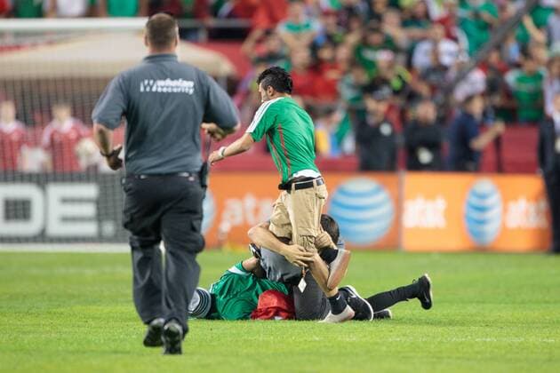 March 31, 2015: Security runs to help as a police officer tackles a 2nd fan after tackling one already as fans rush the field after the CONCACAF international exhibition soccer game between Mexico and Paraguay at Arrowhead Stadium in Kansas City, Missouri. Mexico won 1-0 SOCCER: MAR 31 Paraguay v Mexico Icon1503310590 EDITORIAL USE ONLY