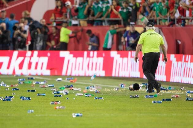 March 31, 2015: A security guard walks among the trash after fans rushed the field and started throwing trash at the police while they tried to subdue the crowd after the CONCACAF international exhibition soccer game between Mexico and Paraguay at Arrowhead Stadium in Kansas City, Missouri. Mexico won 1-0 SOCCER: MAR 31 Paraguay v Mexico Icon1503310632 EDITORIAL USE ONLY