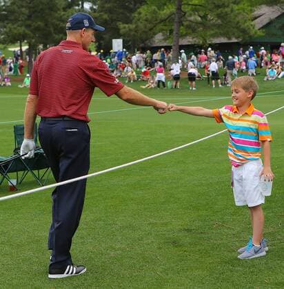 April 6, 2015 - Augusta, GA, USA - Jim Furyk gives a young fan a fist bump walking to the eighth tee box during his practice round on Monday, April 6, 2015, at Augusta National Golf Club in Augusta, Ga. Masters practice round - ZUMAm67_