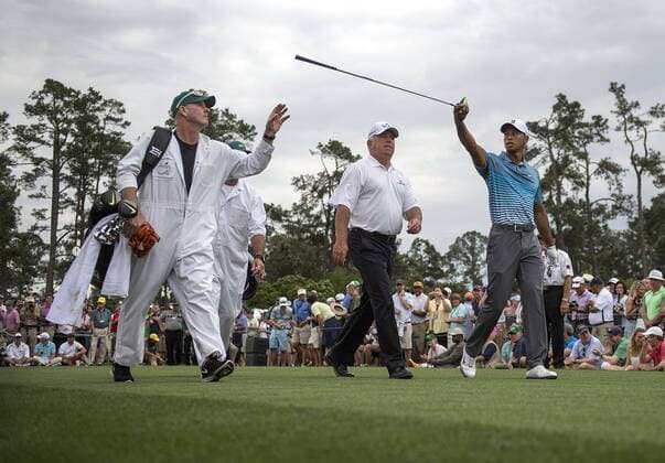 Tiger Woods passes his driver to his caddy Joe LaCava over the head of Mark O Meara after the pair hit off of the first tee during a practice round prior to the 2015 Masters Tournament at Augusta, National in Augusta, Georgia on April 6, 2015.  AUG20150406326 KEVINxDIETSCH