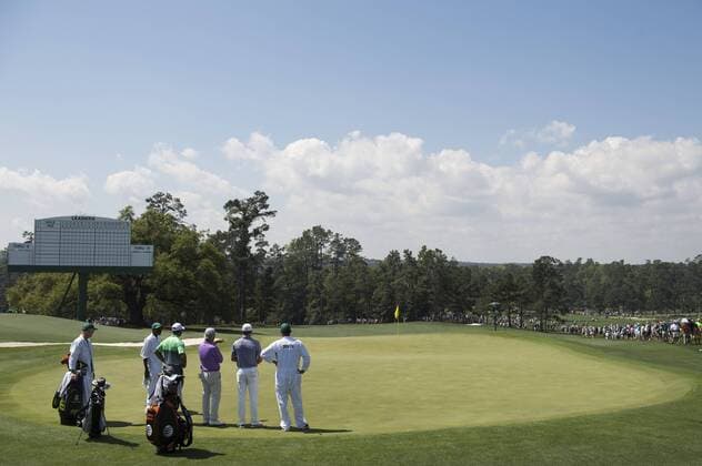Ben Crenshaw, Tiger Woods, Jordan Spieth and their caddies talk after putting on the 18th green during a practice round at the 2015 Masters Tournament at Augusta, National in Augusta, Georgia on April 8, 2015.  AUG20150408327 KEVINxDIETSCH