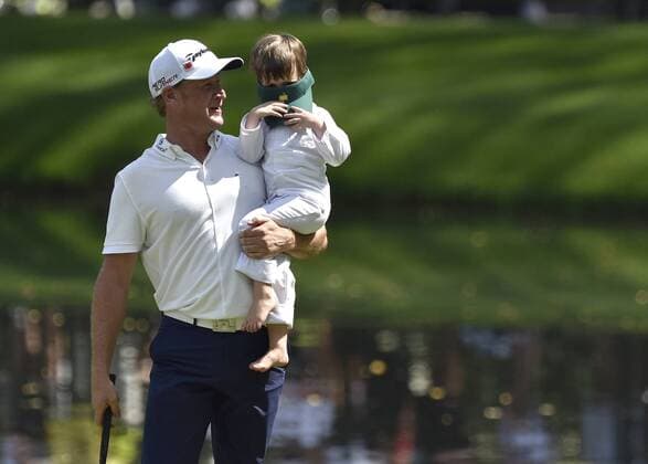 Jamie Donaldson holds his son Max on the 9th green during the Par 3 contest at the 2015 Masters Tournament at Augusta, National in Augusta, Georgia on April 8, 2015.  AUG20150408378 KEVINxDIETSCH